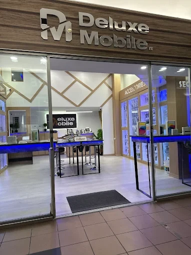 The Deluxe Mobile store front at Excellence City Mall, with the lit sign above glass doors and phone displays inside